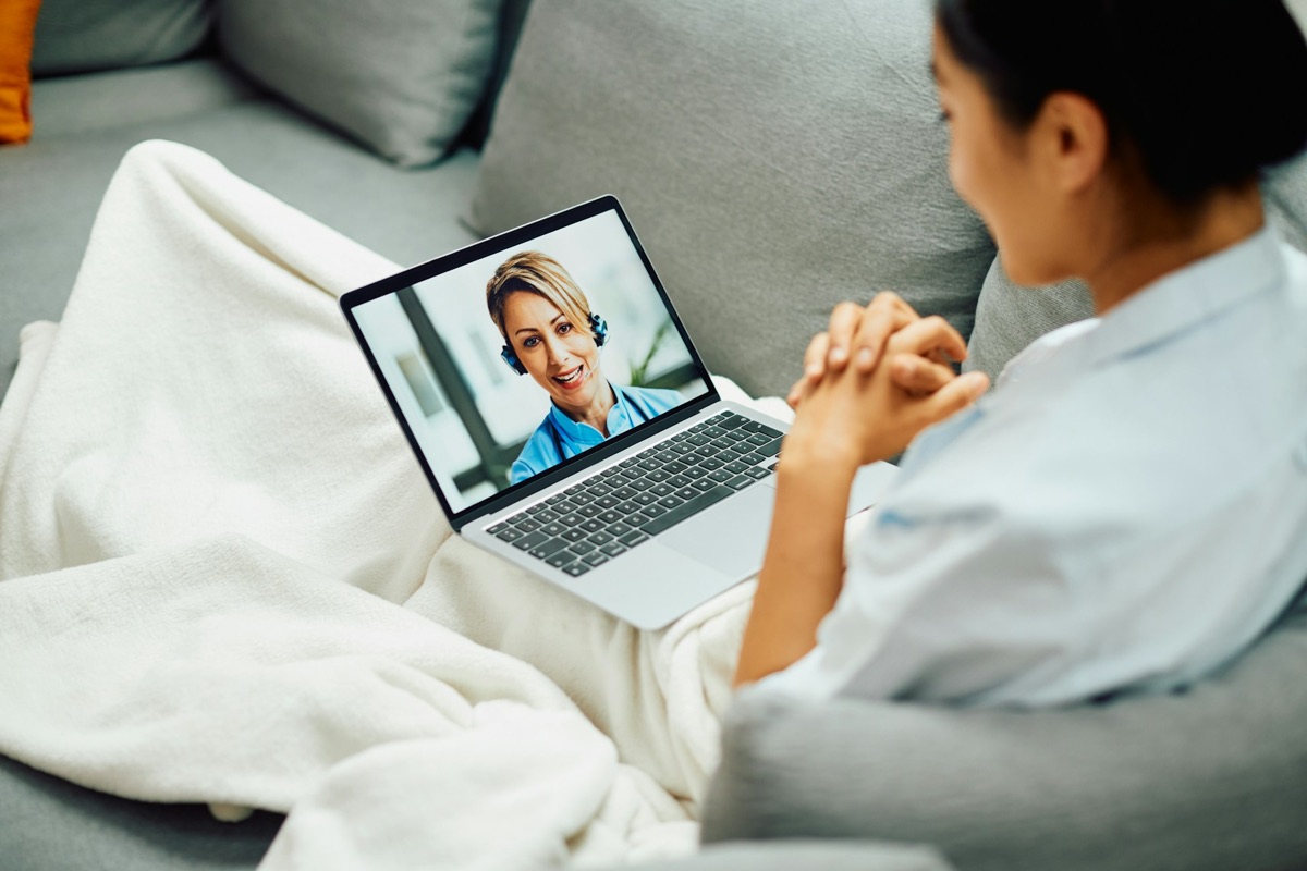 Patient at home on a video consultation with a clinician on her laptop
